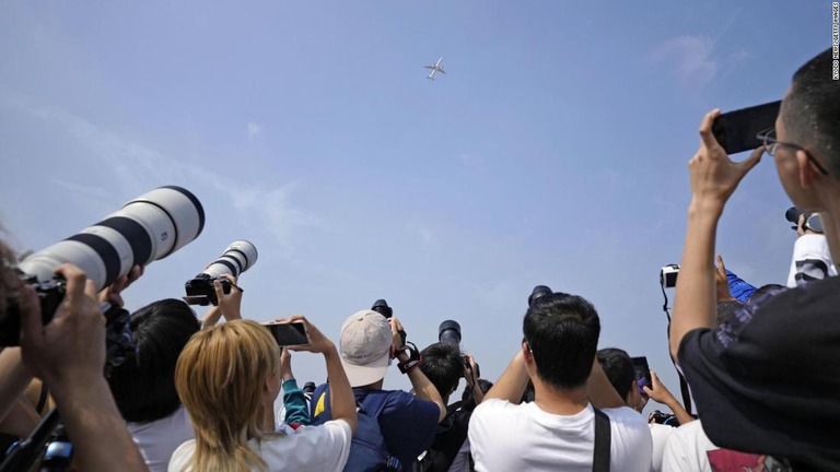 Ｃ９１９の初飛行を撮影する航空ファンら＝５月２８日、北京首都国際空港近郊