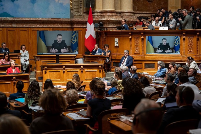 スイスの連邦議会で、スクリーン越しに演説するウクライナのゼレンスキー大統領/Fabrice Coffrini/AFP/Getty Images