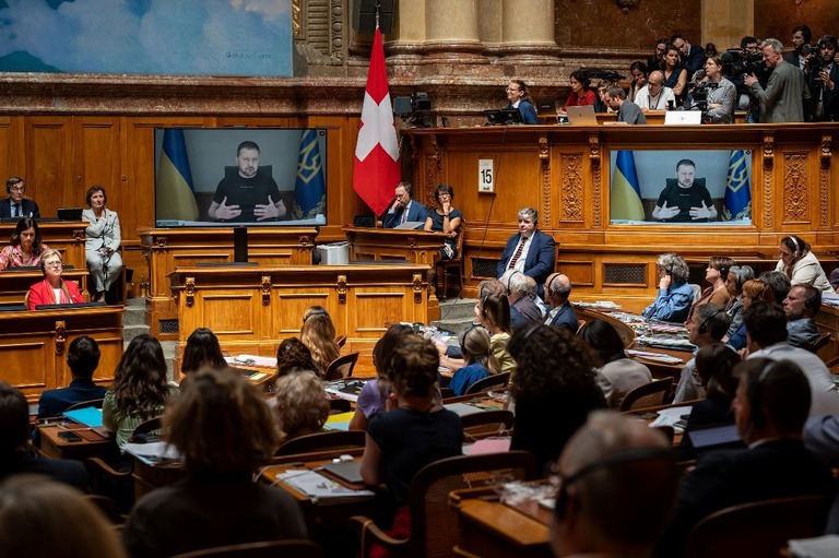 スイスの連邦議会で、スクリーン越しに演説するウクライナのゼレンスキー大統領/Fabrice Coffrini/AFP/Getty Images