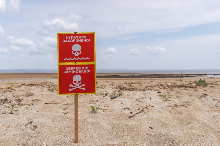 カホウカ貯水池の岸に沿って立てられた地雷の危険を警告する立て札/Kateryna Mykhailova/Global Images Ukraine/Getty Images