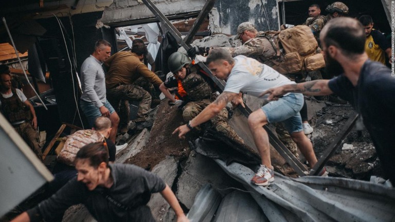 ミサイル攻撃後の瓦礫の中で生存者を捜索する人々/Wojciech Grzedzinski/Anadolu Agency/Getty Images