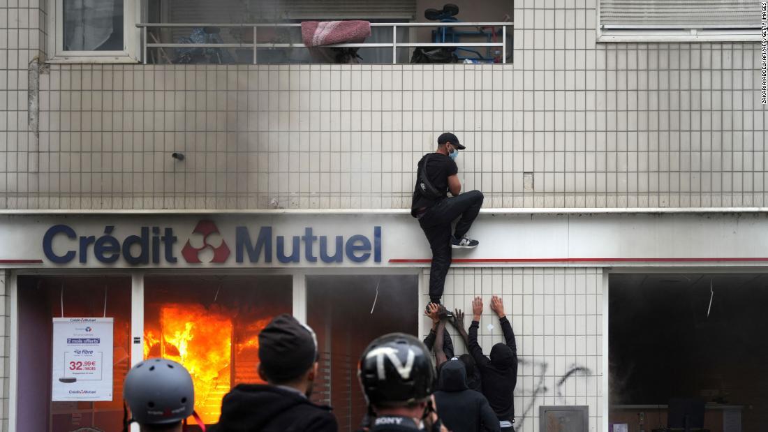 抗議活動中に建物によじ登るデモ参加者/Zakaria Abdelkafi/AFP/Getty Images
