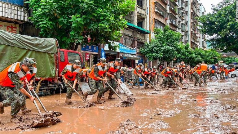 洪水に見舞われた重慶で、排水作業を行う警察官ら/Zou Yi/VCG/Getty Images