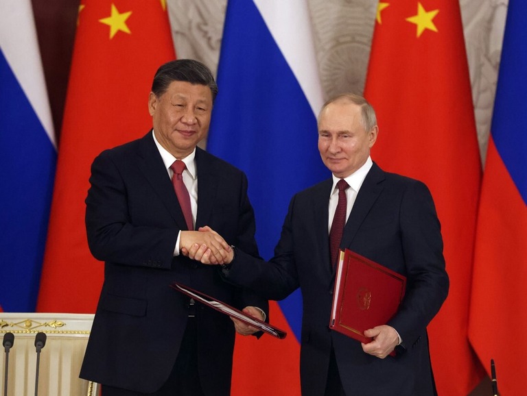 署名式で握手を交わす中国の習近平（シーチンピン）国家主席（左）とロシアのプーチン大統領＝３月２１日、ロシア・モスクワ/Getty Images