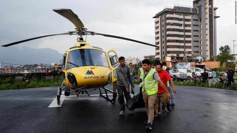 遺体を運ぶ人々＝１１日、ネパールの首都カトマンズのトリブバン大学教育病院/Navesh Chitrakar/Reuters