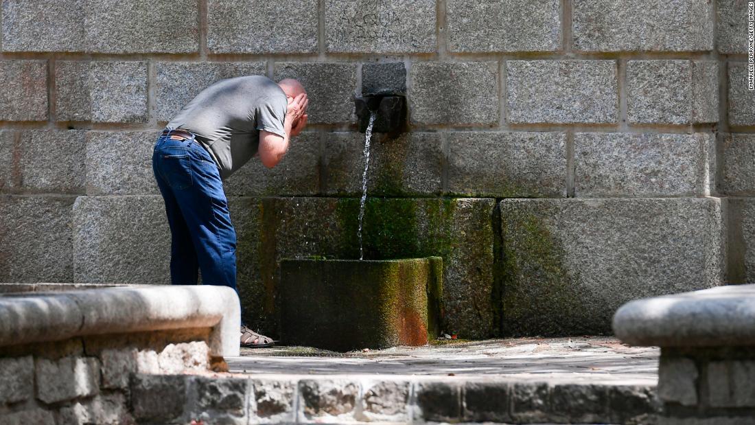 公共噴水で顔を洗う男性＝１１日、イタリア・サルデーニャ島/Emanuele Perrone/Getty Images