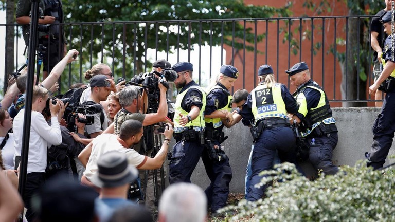 ６月、警官が配備される中、ストックホルムのモスクの外でコーランを燃やすデモ参加者/Caisa Rasmussen/TT News Agency/Reuters/File