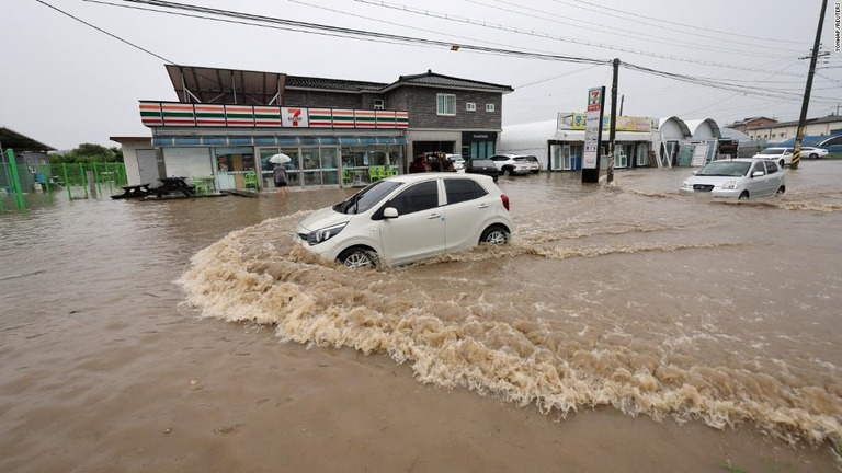 冠水した道路を走る車＝１５日、韓国・清州市/Yonhap/Reuters