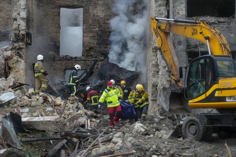 破壊された住居ビルから遺体を運び出すウクライナの救急隊員＝２０日、ミコライウ中心部/Oleksii Filippov/AFP/Getty Images