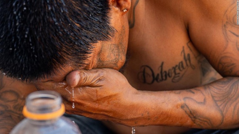猛暑に見舞われた中で顔を洗う人＝１６日、米アリゾナ州フェニックス/Brandon Bell/Getty Images