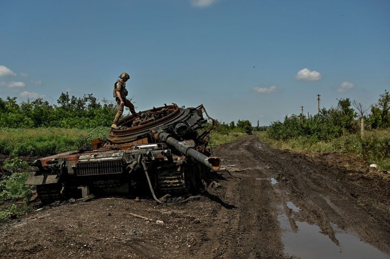 大破したロシア軍の戦車を検査するウクライナ軍兵士＝２１日、ザポリージャ州/Stringer/Reuters
