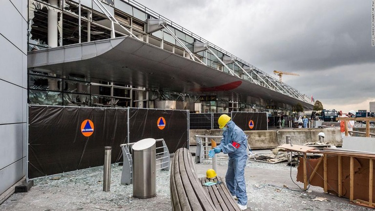 自爆テロが発生した空港のターミナル前で調査を行う捜査官＝２０１６年３月２３日、ベルギー・ブリュッセル/Geert Vanden Wijngaert/AP/FILE