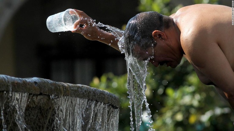 第３熱波の暑さのなか水で体を冷やす男性＝６月１２日、メキシコ・ハリスコ州/Ulises Ruiz/AFP/Getty Images