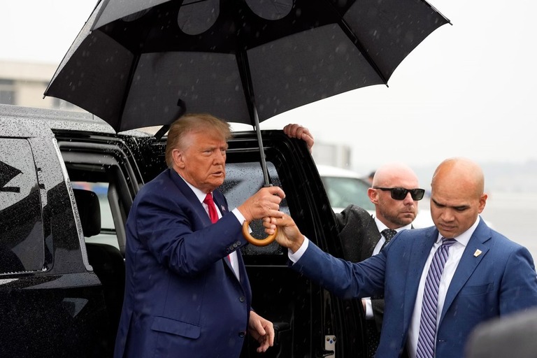 空港で傘を受け取るトランプ大統領＝３日/Alex Brandon/AP