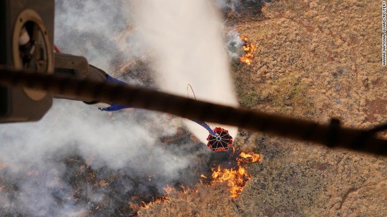 山火事の上空から水の入ったバケツを落とす州兵のヘリコプター＝８月９日/Hawaii National Guard/Reuters