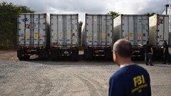 マウイ島の町ワイルクにある警察の検視施設に到着した冷凍車を見つめるＦＢＩ要員＝８月１４日