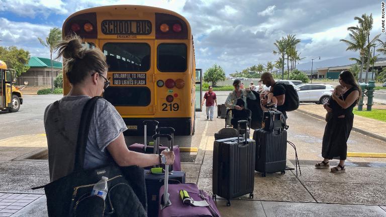避難のためスクールバスで空港に到着した人々＝８月１０日/Claire Rush/AP