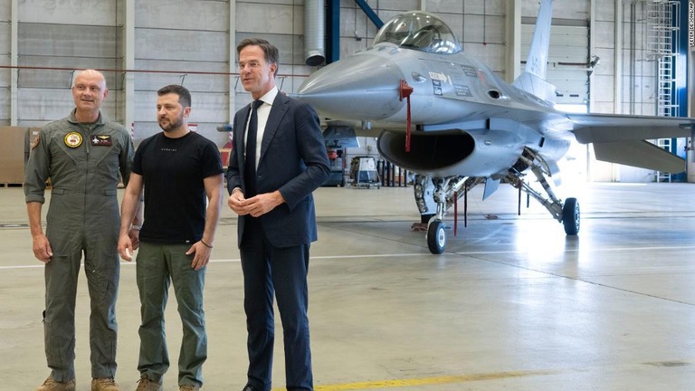 Ｆ１６戦闘機の前に立つオランダのルッテ首相（右）とウクライナのゼレンスキー大統領（中央）＝２０日、オランダ・アイントホーフェン/Peter Dejong/AP