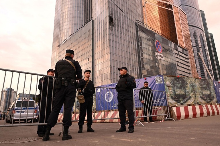 損傷した建物の横に立つ警官ら＝２３日、ロシア首都モスクワ/Natalia Kolesnikova/AFP/Getty Images