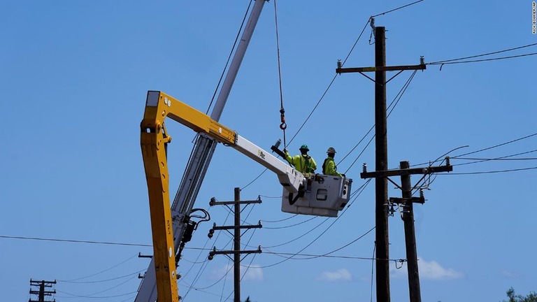 電線で作業する作業員＝１３日、米ラハイナ/Rick Bowmer/AP