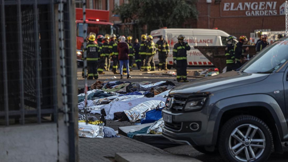 毛布やシーツに包まれた遺体が建物の外に置かれた/Michele Spatari/AFP/Getty Images