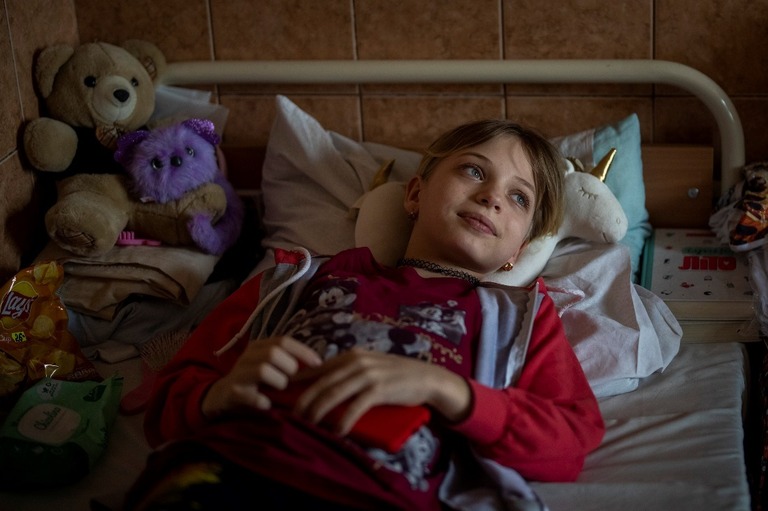 ベッドに横たわるヤナ・ステパネンコさん＝２０２２年５月、ウクライナ・リビウ/Emilio Morenatti/AP