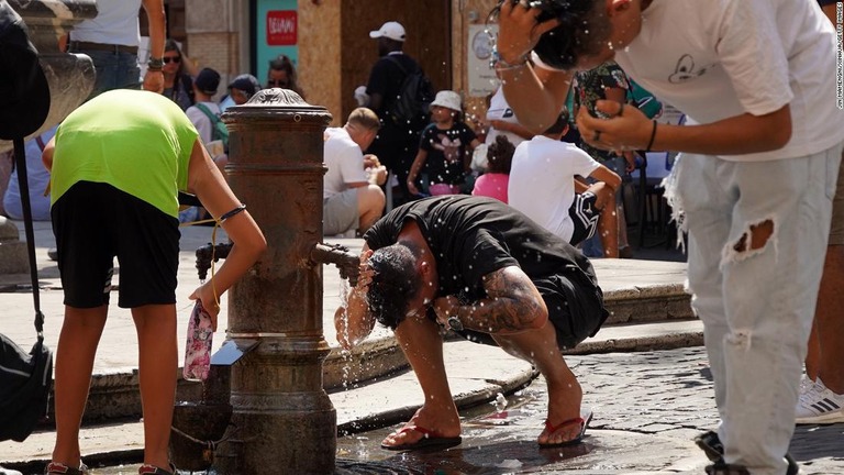 水や浴びるなどして暑さ対策をする人々＝８月２２日、イタリア・ローマ/Jin Mamengni/Xinhua/Getty Images