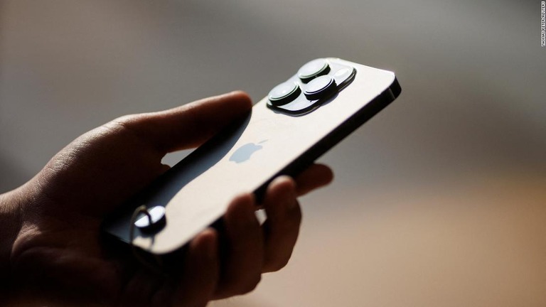 ｉＰｈｏｎｅを持つ男性＝２０２２年９月１６日、中国北京のアップルストア/Thomas Peter/Reuters
