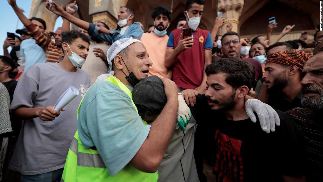 洪水で家族を失った友人を慰める人々/Zohra Bensemra/Reuters