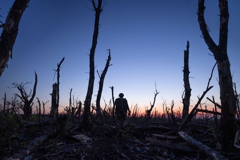 戦闘で焼けた森林を抜けて前進するウクライナの兵士/Mstyslav Chernov/AP