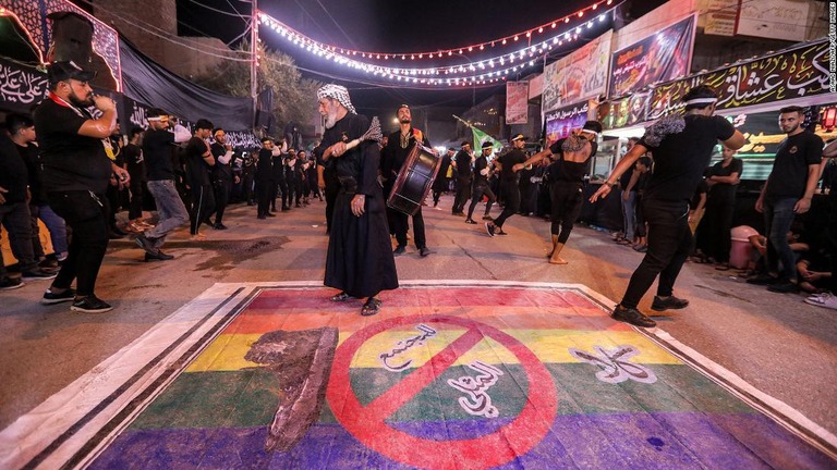 同性愛に反対するイスラム教徒の信者ら。幕にはレインボーフラッグにアラビア語で「同性愛社会にノー」の文字が書かれている＝７月２５日、イラク南部ナシリヤ/Asaad Niazi/AFP/Getty Images
