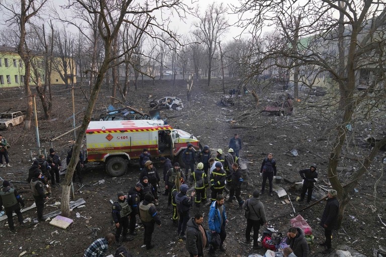攻撃によって損傷した産科病院の外に集まるウクライナの兵士や救急隊＝２０２２年３月、ウクライナ・マリウポリ/Evgeniy Maloletka/AP/File