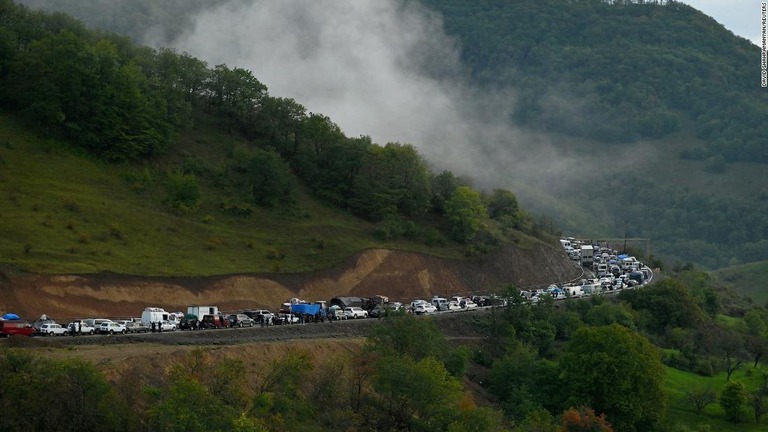 ナゴルノ・カラバフから避難する人々を乗せた車列/David Ghahramanyan/Reuters
