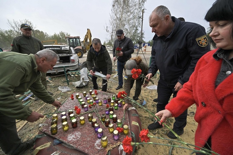 フロザ村への攻撃の犠牲者に花やキャンドルを捧げる人々/Genya Savilov/AFP/Getty Images