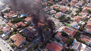 ロケット弾による攻撃で車両が炎上するイスラエル南部アシュケロンの街の様子