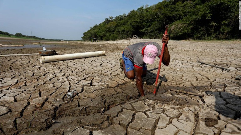 水を求め、ひび割れた湖底で井戸を掘ろうとする男性/Michael Dantas/AFP/Getty Images