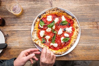 トマトとモッツァレラ、バジルの葉だけを載せたシンプルなナポリタン・ピザ