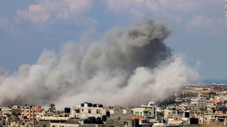 １６日、イスラエル軍による空爆を受けて煙が立ち込めるガザ地区南部