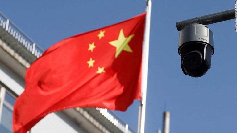 北京市内に掲げられた中国国旗と設置された監視カメラ/Carlos Garcia Rawlins/Reuters/File