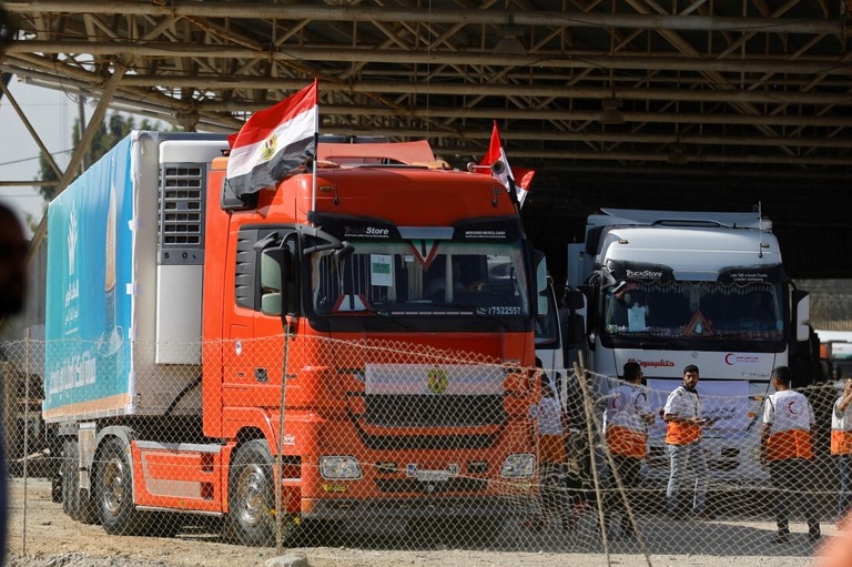 人道支援物資を積んだトラックが境界のパレスチナ側に到着する様子＝２１日、ガザ地区/Ibraheem Abu Mustafa/Reuters