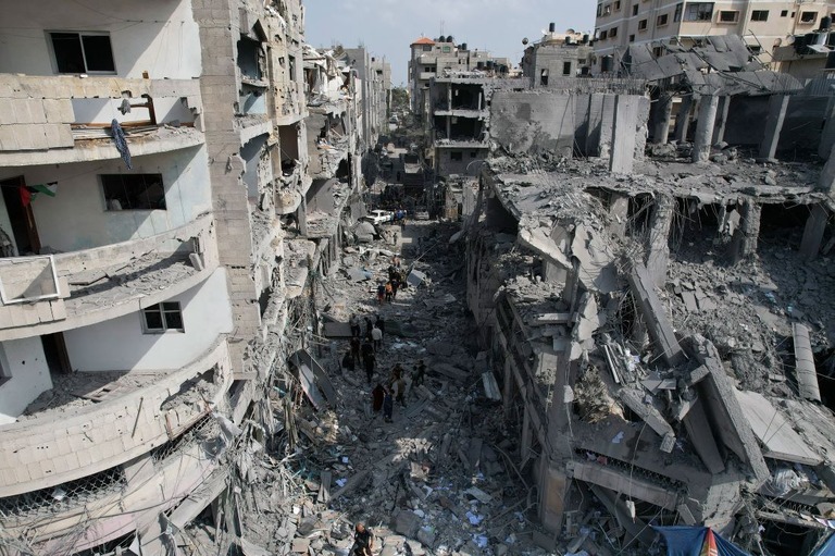 ２２日、イスラエル軍によるガザ地区への空爆後、生存者を探すパレスチナ人ら/Hatem Moussa/AP