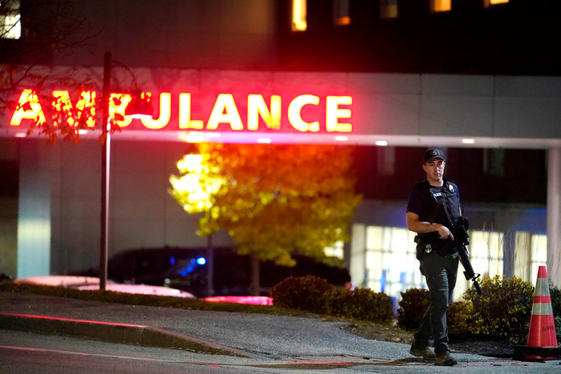 病院前で警戒に当たる地元警察官=25日、米メーン州ルイストン/Steven Senne/AP