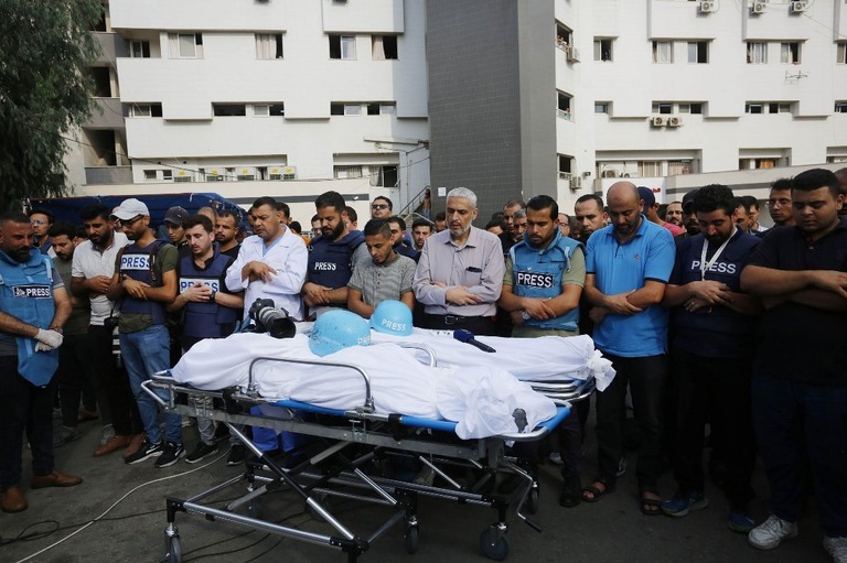 イスラエルによるガザの空爆で死亡したパレスチナ人記者の葬儀で祈りを捧げる人々/Ashraf Amra/Anadolu/Getty Images