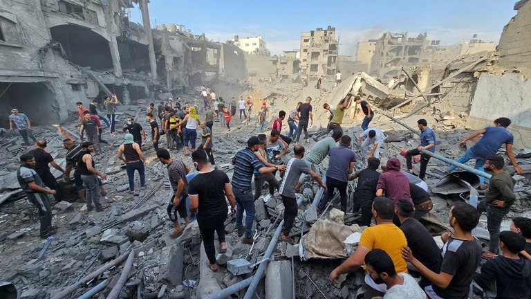 ガザ北部のジャバリヤ難民キャンプへの空爆後、犠牲者の捜索を行うパレスチナ人ら/Anas al-Shareef/Reuters
