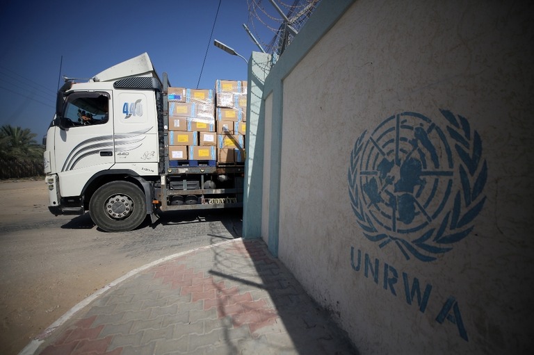 ＵＮＲＷＡのロゴが書かれた施設からトラックで運び出される支援物資/Majdi Fathi/NurPhoto/Getty Images