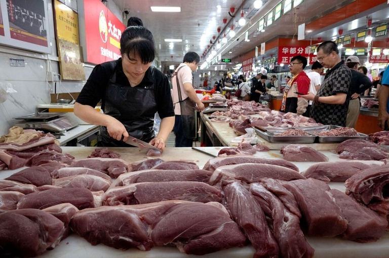 豚肉を切り分ける精肉店の店員＝９月７日、中国・北京の生鮮市場/Bloomberg/Getty Images