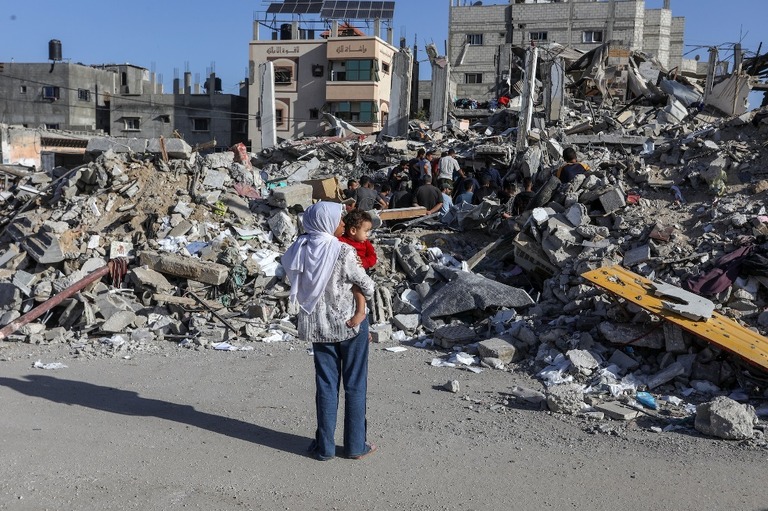 イスラエル軍による空爆で破壊された建物のがれきを調べるパレスチナの人々＝１０日、パレスチナ自治区ガザ地区ラファ/Abed Rahim Khatib/Anadolu Agency/Getty Images