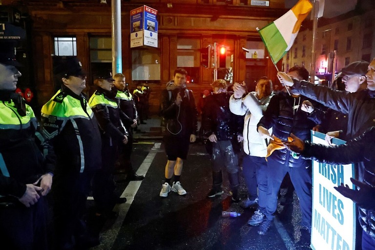 機動隊の前に立つ人々＝アイルランド・ダブリン/Clodagh Kilcoyne/Reuters