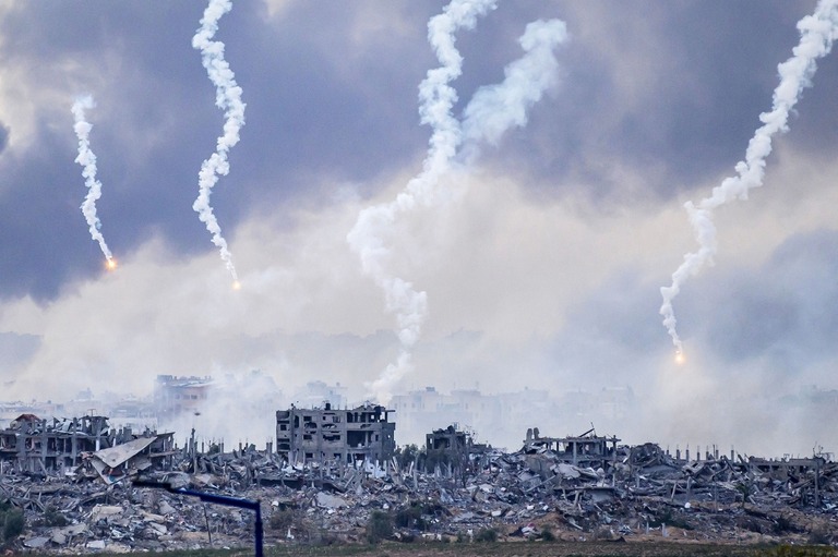 イスラエル軍の空爆で、ガザ北部に落下するフレア弾/John MacDougall/AFP/Getty Images