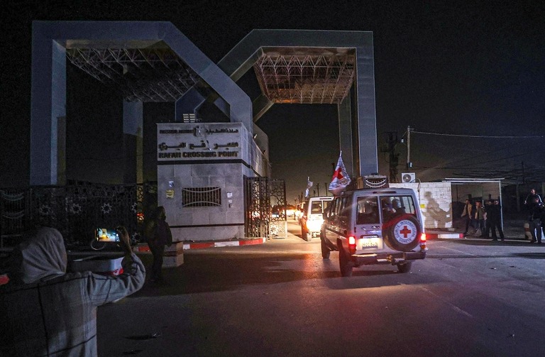 解放された人質を乗せ、ガザ境界のラファ検問所を通過する国際赤十字の車両/Mustafa Hassona/Anadolu/Getty Images
